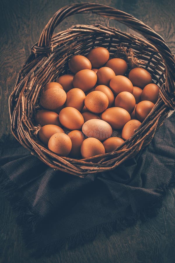 Organic brown eggs in a basket on wooden table royalty free stock photos
