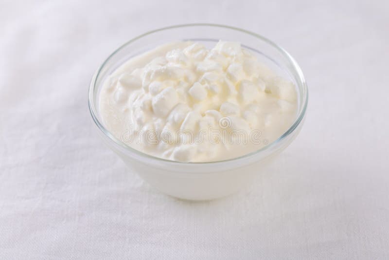 Organic cottage cheese in a bowl on kitchen table stock photo