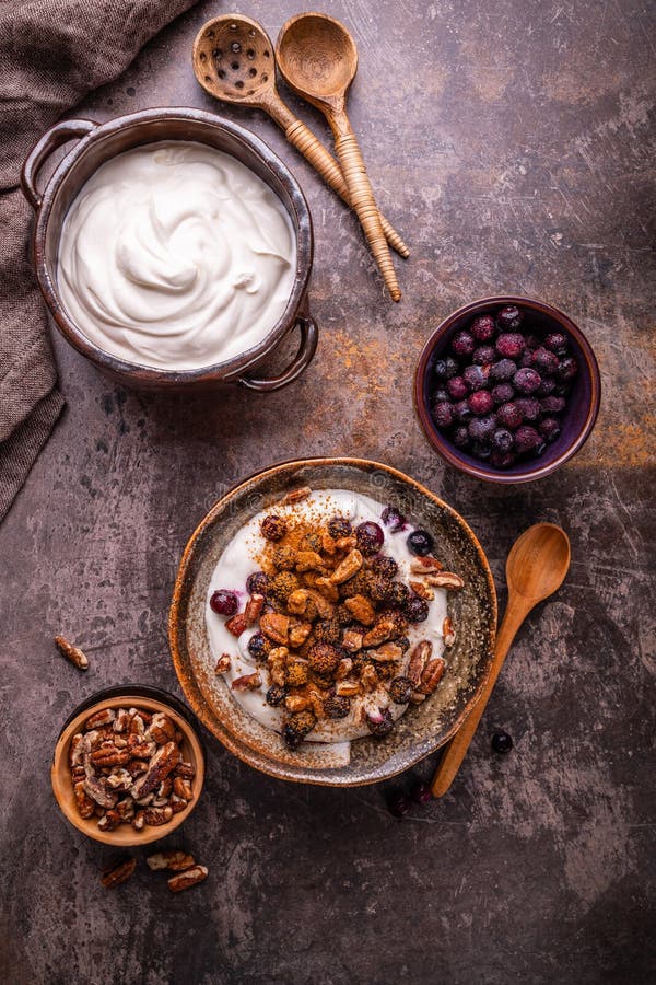 Organic Greek yogurt with pecan nuts, blueberries and cinnamon stock photo