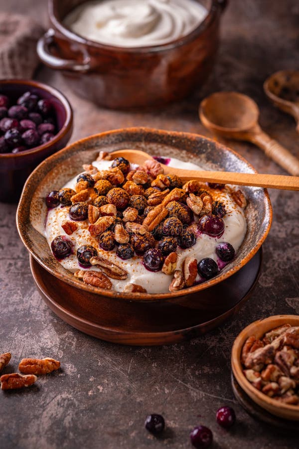Organic Greek yogurt with pecan nuts, blueberries and cinnamon royalty free stock photos