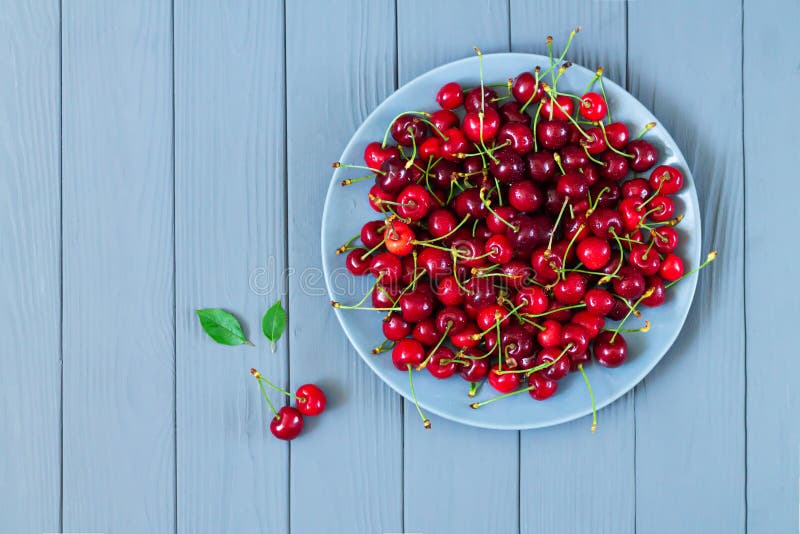 Organic wet sweet cherry on plate on table