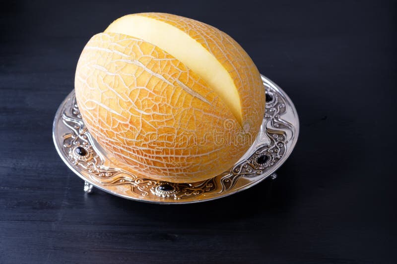 Organicznie melonu cięcie składa obsiadanie na srebnej tacy zdjęcie stock Organicznie melonu cięcie składa obsiadanie na srebnej tacy zdjęcie stock