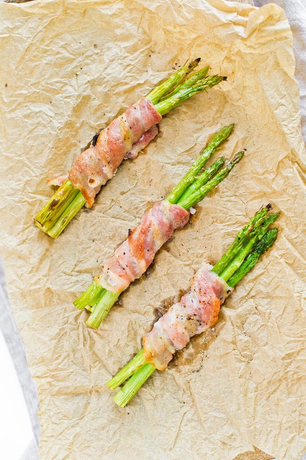 Organische groene minidieasperge in bacon op houten scherpe Raad wordt verpakt Witte achtergrond, hoogste mening stock afbeeldingen Organische groene minidieasperge in bacon op houten scherpe Raad wordt verpakt Witte achtergrond, hoogste mening stock afbeeldingen