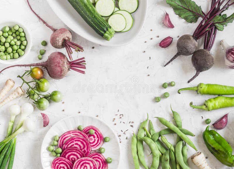 Organiska purpurfärgade och gröna grönsaker på en vit bakgrund Detoxingredienser Sunt vegetariskt matbegrepp Bästa sikt, fri brun