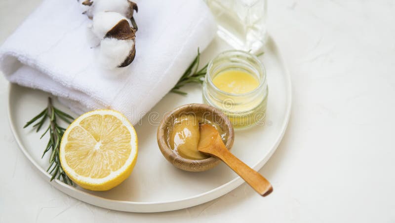 Organic skincare ingredients with towels and manuka honey, natural treatments ingredients with lemon, honey, balm salve, rosemary herb, spa still life setting. Organic skincare ingredients with towels and manuka honey, natural treatments ingredients with lemon, honey, balm salve, rosemary herb, spa still life setting