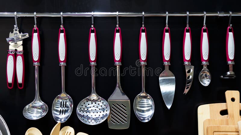 Organization of the Interior of Home Space and Storage of Household Utensils Kitchen Tools and Equipment Spoons Ladles Knives. Neatly Hang on a Railing against stock photo