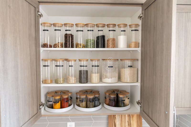 Organized labeled food pantry in a home kitchen with spices grains flour rice sugar nuts
