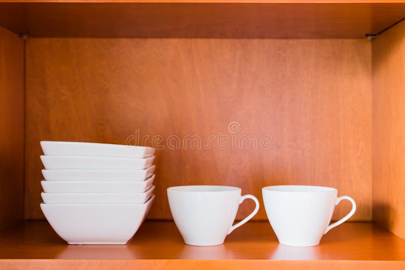 Organized minimalistic kitchen cabinet with white porcelain bowl