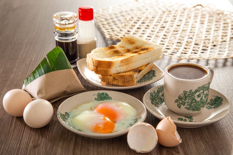 Oriental breakfast set in Malaysia consisting of coffee, nasi lemak, toast bread and half-boiled egg