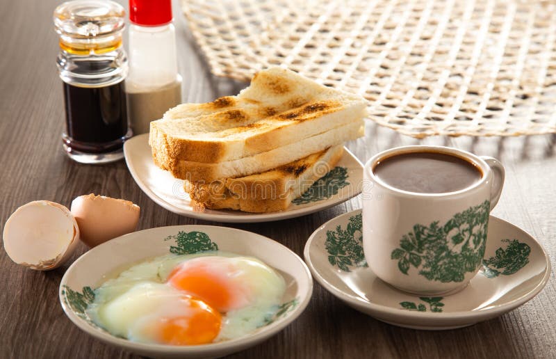 Oriental breakfast set in Malaysia consisting of coffee, nasi lemak, toast bread and half-boiled egg