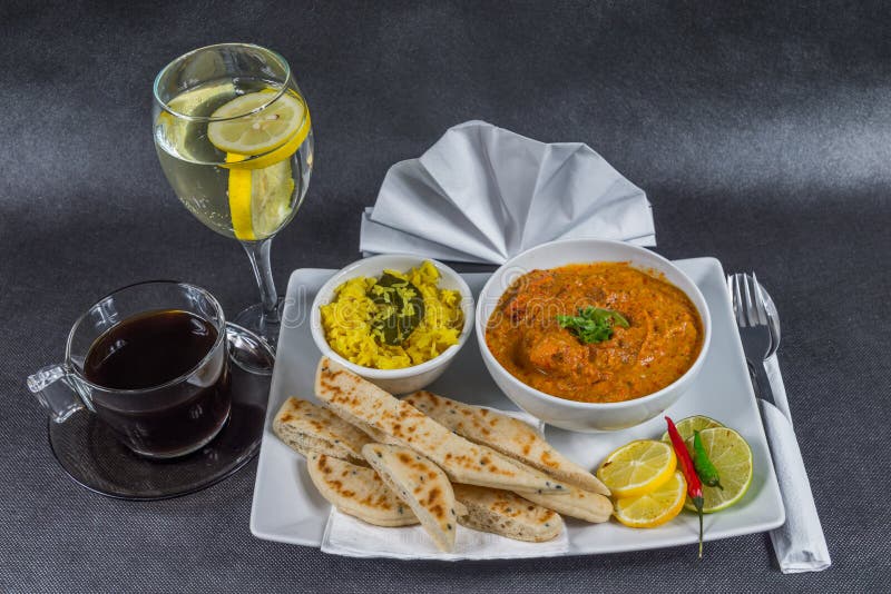 Oriental Indian set, chicken tikka masala, naan bread, white plate, black coffee, water, napkin, peppers, tasty set