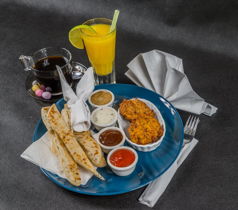 Oriental Indian set, naan bread and onion bhaji, four sauces, blue plate, black coffee, orange juice, tasty set