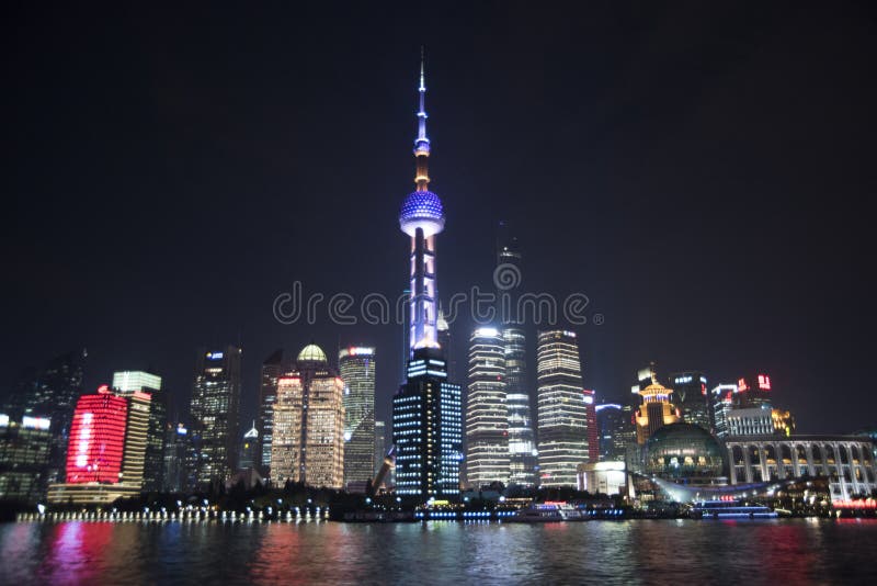 Oriental Pearl Tower and surrounding buildings seen across the Huangpu River at night. Oriental Pearl Tower and surrounding buildings seen across the Huangpu River at night.