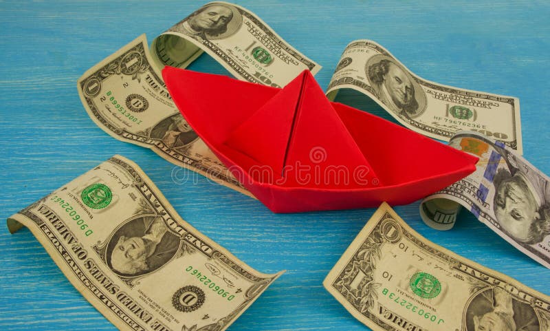 Origami paper boat at sea of money / american moneys of hundred