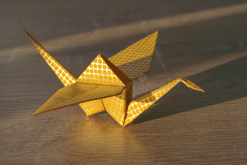 Origami Papiervogel Gelbes Goldmuster des japanischen Papiers Origami streckt sich auf hölzernem Hintergrund stockfotos Origami Papiervogel Gelbes Goldmuster des japanischen Papiers Origami streckt sich auf hölzernem Hintergrund stockfotos