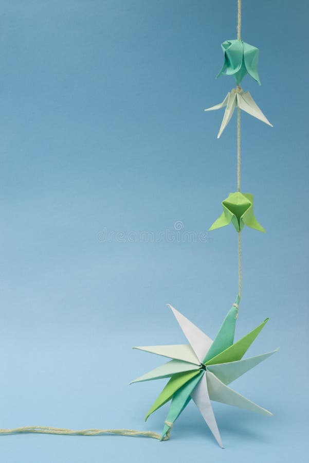 Star shaped paper origami on thread with tiny elements against blue background. Decagon stock images, royalty-free photos and pictures