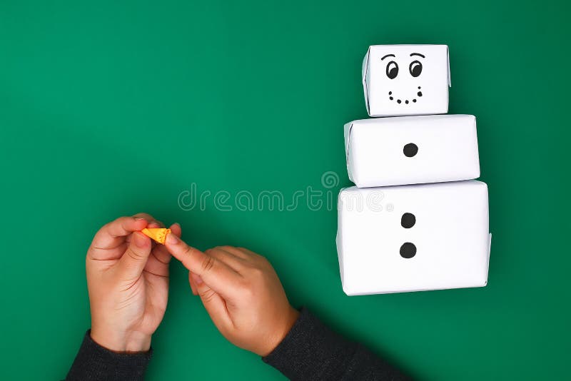 The original design of the three Christmas gift of white paper, a satin ribbon in the form of a snowman on a green background. royalty free stock image The original design of the three Christmas gift of white paper, a satin ribbon in the form of a snowman on a green background. royalty free stock image