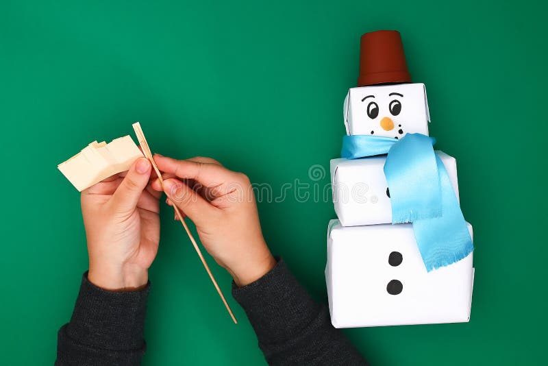 The original design of the three Christmas gift of white paper, a satin ribbon in the form of a snowman on a green background. stock photos The original design of the three Christmas gift of white paper, a satin ribbon in the form of a snowman on a green background. stock photos