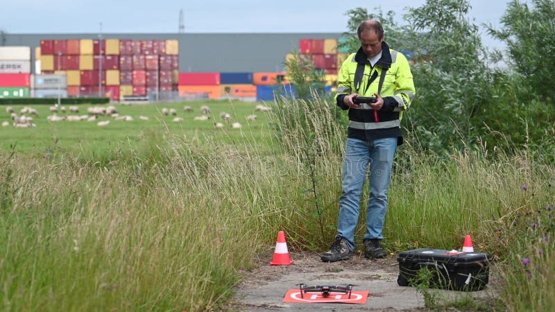 Original drone pre-flight with five words. Man, wearing a reflective coat preforming pre-flight checks before lift off of his drone for an inspection flight