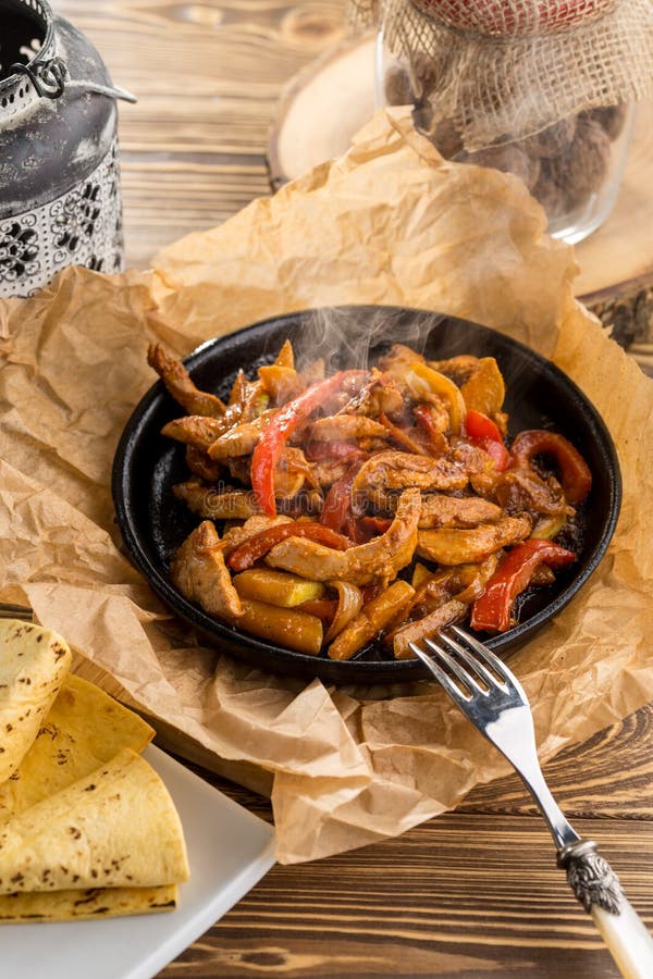 Original fajita sizzling smoking hot served on iron plate on wooden table stock photos Original fajita sizzling smoking hot served on iron plate on wooden table stock photos