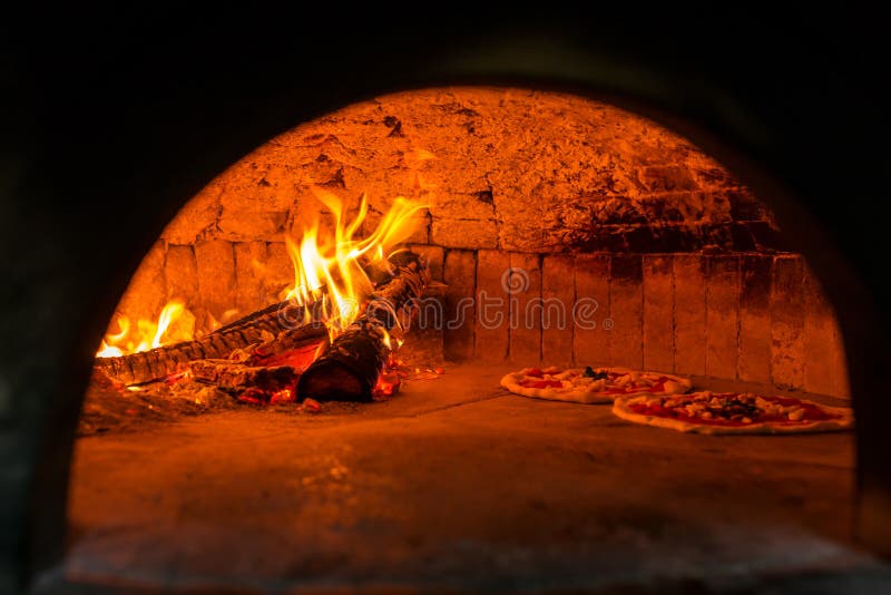 Original neapolitan pizza margherita in a traditional wood oven in Naples restaurant, Italy. Original neapolitan pizza margherita in a traditional wood oven in Naples restaurant, Italy