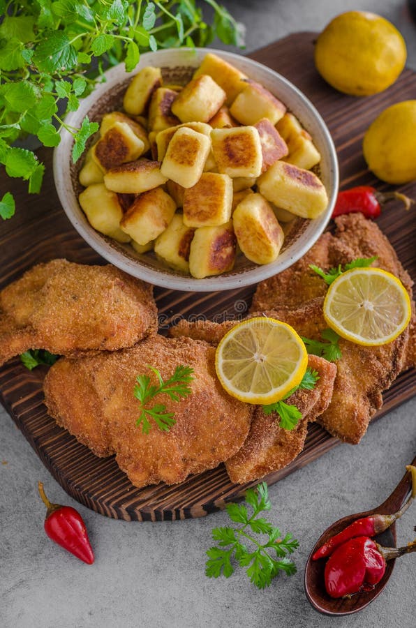 Originale della cotoletta con il limone e gnocchi fritti immagini stock libere da diritti Originale della cotoletta con il limone e gnocchi fritti immagini stock libere da diritti