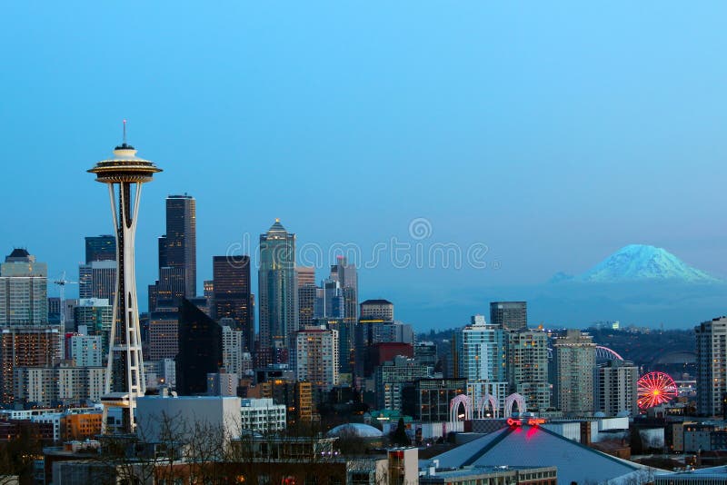 Orizzonte di Seattle nel tramonto con l'ago e la montagna dello spazio più piovosi immagini stock libere da diritti Orizzonte di Seattle nel tramonto con l'ago e la montagna dello spazio più piovosi immagini stock libere da diritti
