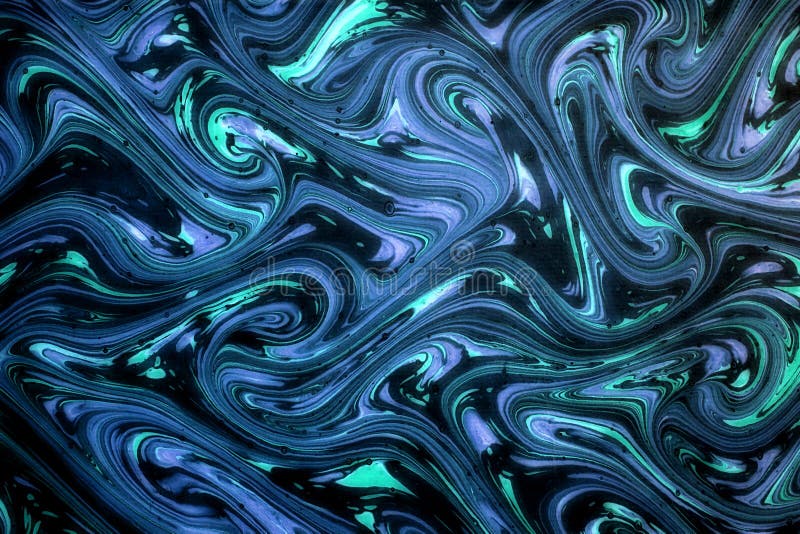 Ornamental blue swirling marbled paper with a flowing sinuous design on a dark background in a full frame background pattern. Ornamental blue swirling marbled paper with a flowing sinuous design on a dark background in a full frame background pattern