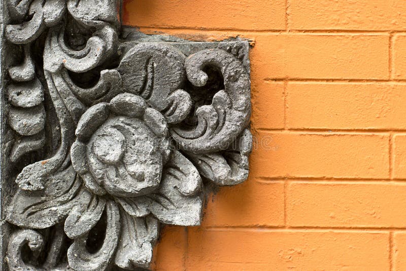Ornamento della decorazione del fiore del cemento sul muro di mattoni arancio fotografie stock libere da diritti Ornamento della decorazione del fiore del cemento sul muro di mattoni arancio fotografie stock libere da diritti