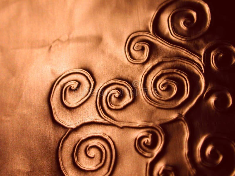 Ornate Spirals Pattern Texture. A background texture pattern of swirls and spirals indented into a copper colored metal lic surface Ornate Spirals Pattern Texture. A background texture pattern of swirls and spirals indented into a copper colored metal lic surface