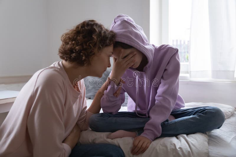 Worried parent young mom comforting depressed crying teen daughter bonding at home. Loving understanding mother apologizing or supporting sad teenage girl having psychological puberty problem concept. Worried parent young mom comforting depressed crying teen daughter bonding at home. Loving understanding mother apologizing or supporting sad teenage girl having psychological puberty problem concept.