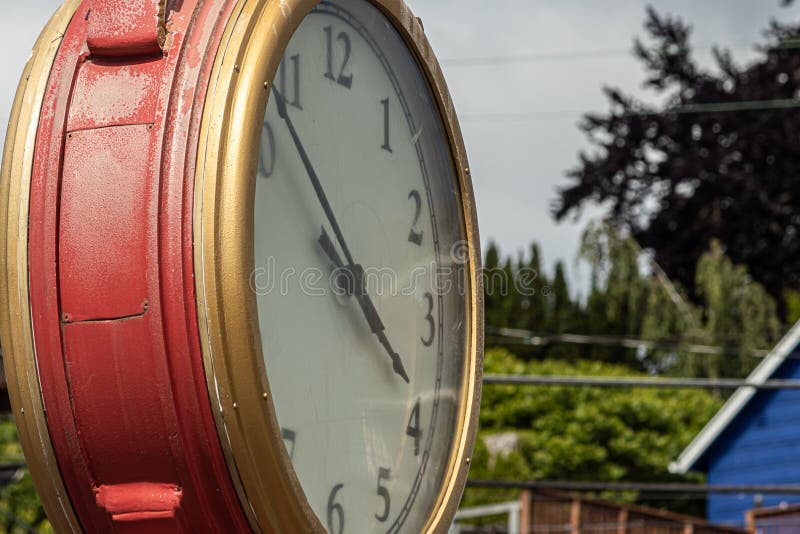 Orologio all'aperto dell'oro e rosso contro sfondo naturale in città immagini stock Orologio all'aperto dell'oro e rosso contro sfondo naturale in città immagini stock