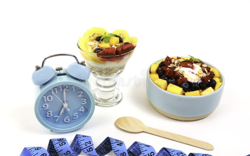 Orologio blu per il concetto di digiuno intermittente e per mangiare cibo sano e yogurt parfait alimenti dietetici sani immagine stock