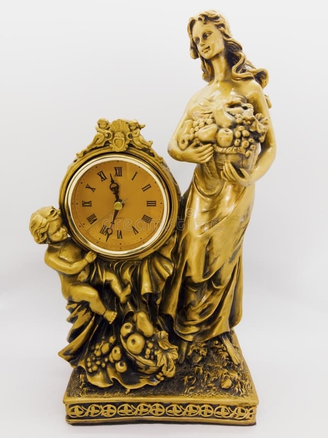 Orologio bronzeo, donna che tengono un canestro di frutta e ragazzino dello scrittorio immagini stock Orologio bronzeo, donna che tengono un canestro di frutta e ragazzino dello scrittorio immagini stock