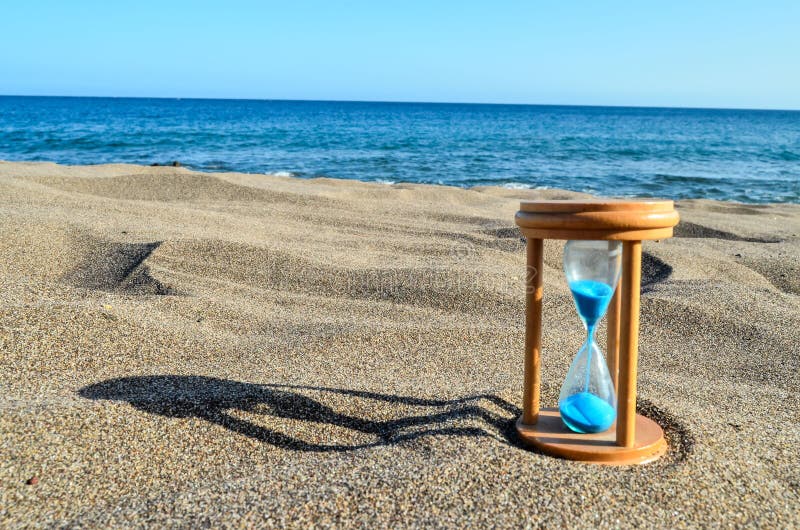 Orologio della clessidra sulla spiaggia di sabbia
