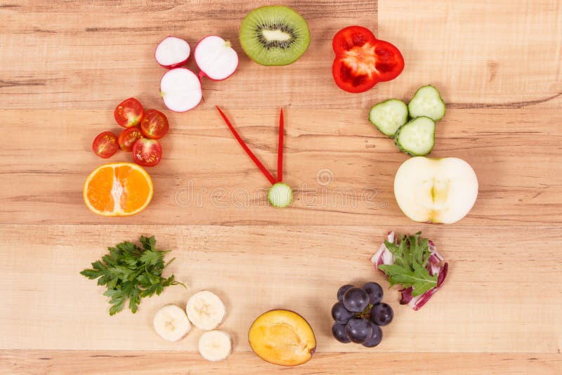 Orologio fatto della frutta e delle verdure che contengono i minerali, tempo per le risoluzioni del concetto sano di nutrizione fotografie stock