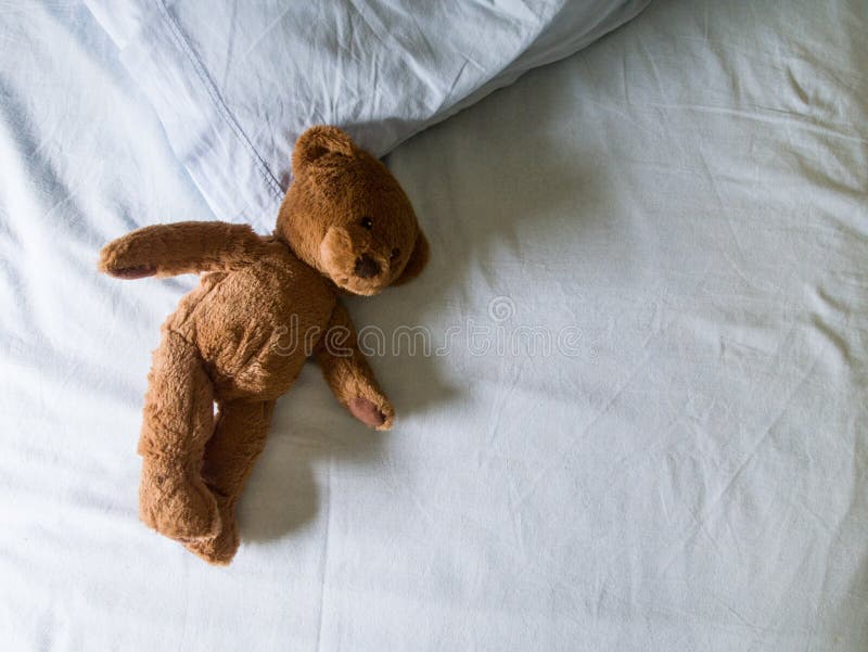 Orsacchiotto lasciato sul letto fotografia stock Orsacchiotto lasciato sul letto fotografia stock