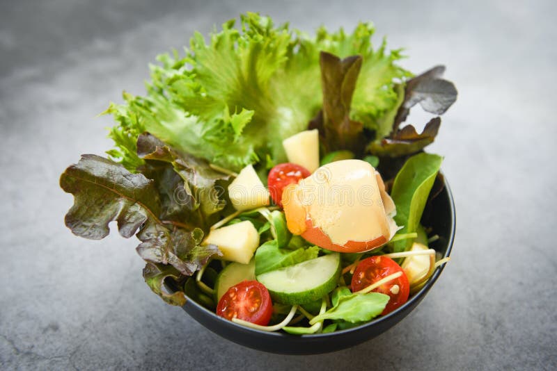 Ortaggi di insalata con l'insalata di uova con frutta e cetrioli freschi del pomodoro di lattughe sulla tazza sul concetto sano di immagini stock