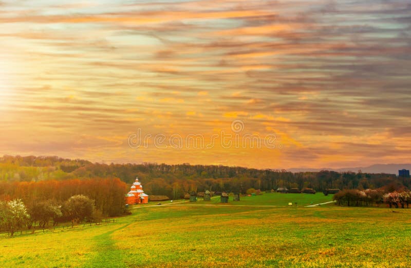 An orthodox church in a yellow field in a rural countryside area of Ukraine at sunset