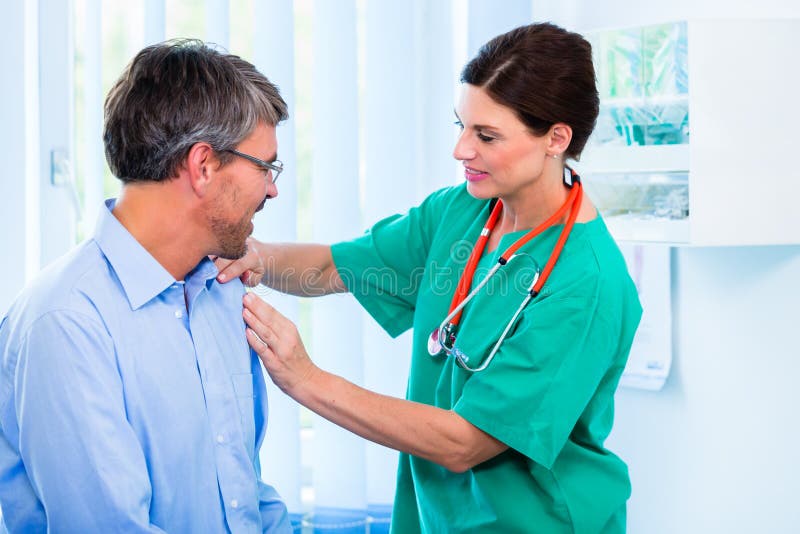 Orthopedist examining shoulder of patient in surgery stock photography