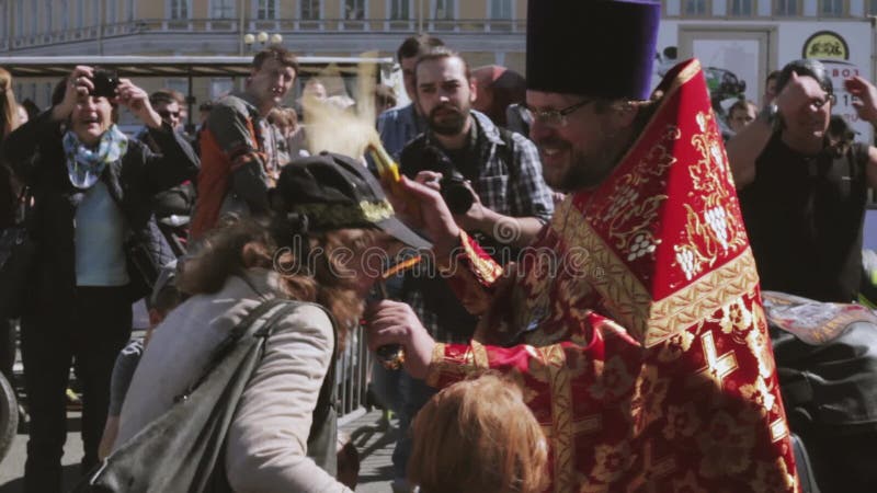Ortodoksalny ksiądz kropi świętą wodę zaludniać Rowerzysty przedstawienie i parada