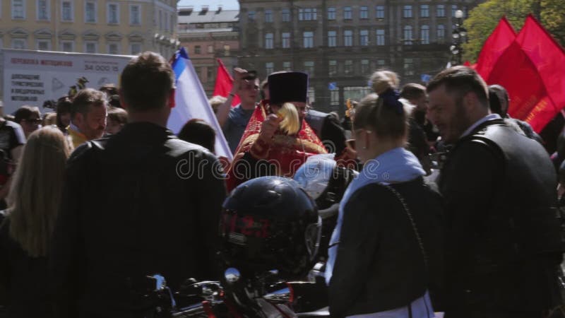 Ortodoksalny ksiądz kropi świętą wodę zaludniać Rowerzysty przedstawienie i parada