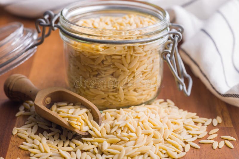 Orzo, kritharaki, risoni pasta. Uncooked dry pasta on wooden table stock images
