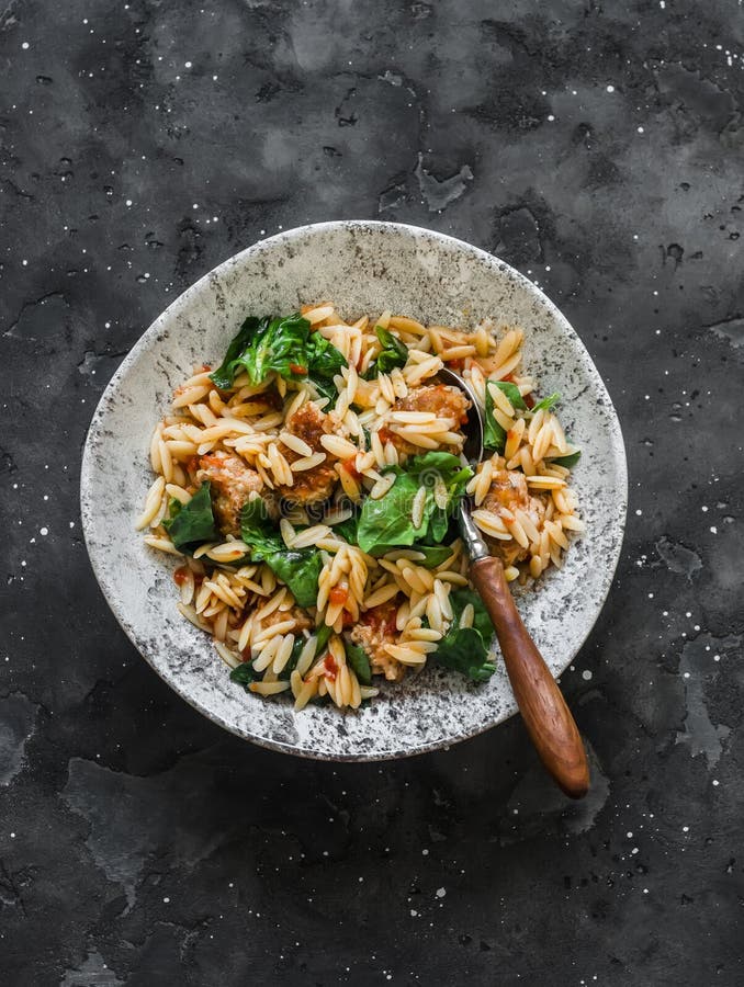 Orzo Pasta with Meatballs and Spinach in Tomato Sauce on a Dark