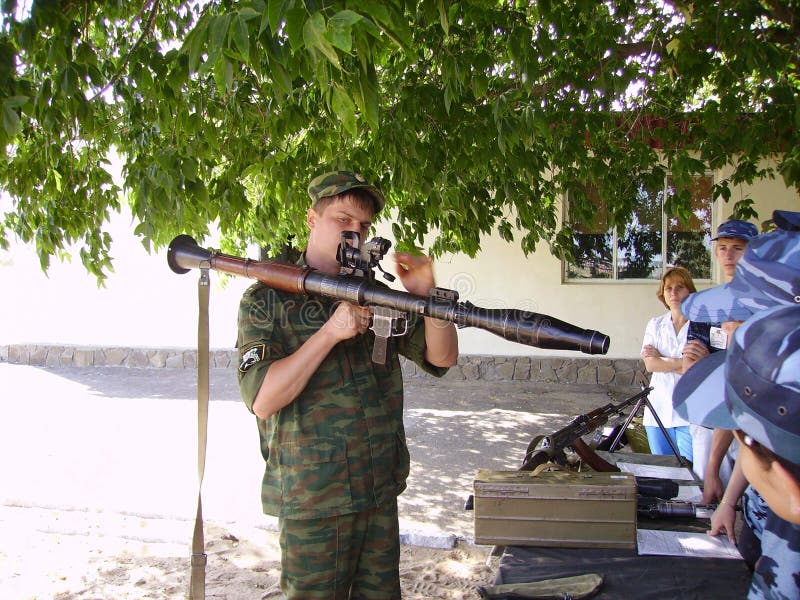 Os adolescentes mostram armas modernas na base militar do russo imagem de stock Os adolescentes mostram armas modernas na base militar do russo imagem de stock