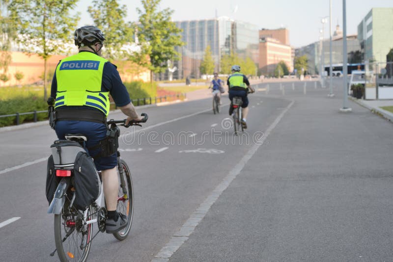 Os agentes da polícia em bicicletas patrulham as ruas em Helsínquia, Finlandia foto de stock Os agentes da polícia em bicicletas patrulham as ruas em Helsínquia, Finlandia foto de stock