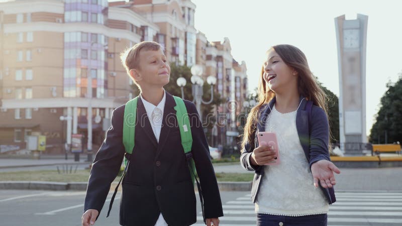 Os alunos estão andando ao longo da rua da cidade