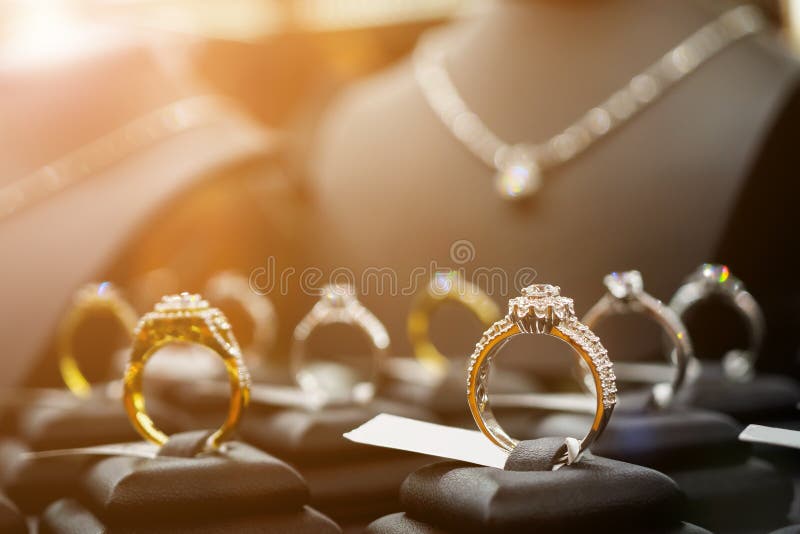 Os aneis de diamante e as colares da joia mostram na loja luxuosa