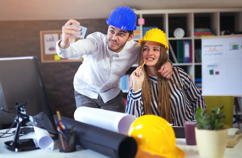 Os arquitetos novos fazem a foto do selfie no escritório foto de stock Os arquitetos novos fazem a foto do selfie no escritório foto de stock