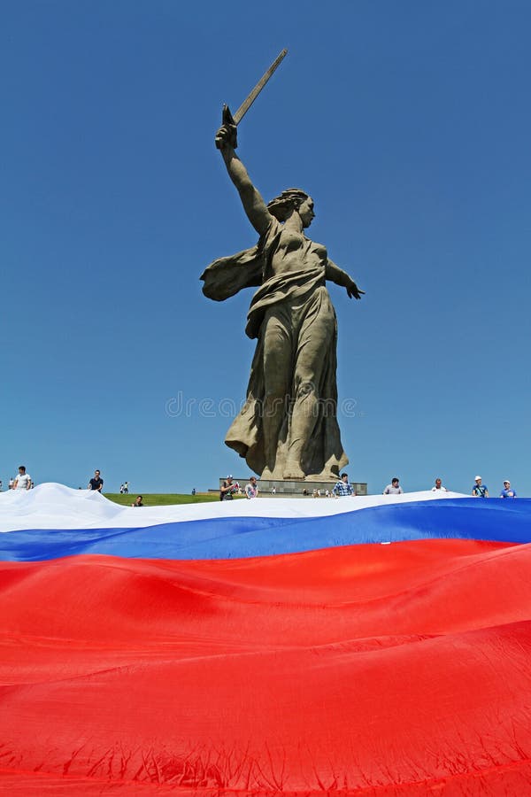 Os ativistas unfurl um grande russo que a bandeira no dia de Rússia no pé do monumento da pátria chama o monte de Mamaev em Volgo foto de stock royalty free Os ativistas unfurl um grande russo que a bandeira no dia de Rússia no pé do monumento da pátria chama o monte de Mamaev em Volgo foto de stock royalty free